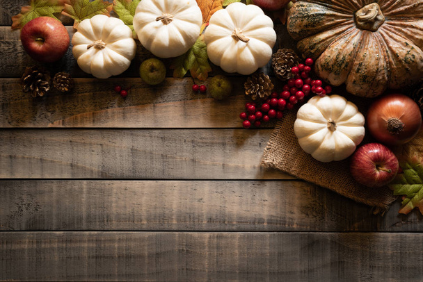 Bovenaanzicht van Autumn maple laat met pompoen en rode bessen op oude houten achtergrond. Thanksgiving day concept. - Foto, afbeelding
