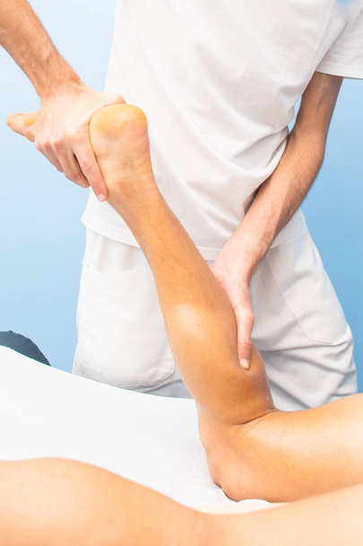 La fisioterapia pratica un massaggio drenante nel polpaccio a un atleta
. - Foto, immagini