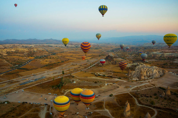 Cappadocia, Turkey: Balloon flight at dawn, beautiful view of the mountains and balls. Hot air balloon flying over spectacular Cappadocia under the sky. - Photo, image