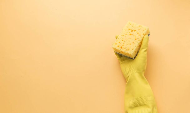 Flat lay Detergents and cleaning accessories and womens hands in rubber gloves in yellow color. Cleaning service concept. Flatlay, Top view. - 写真・画像