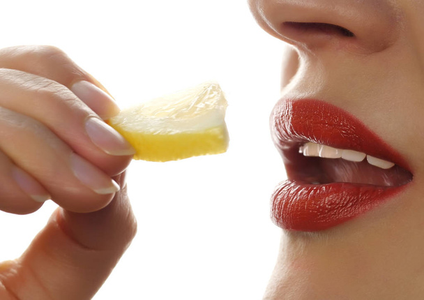 beautiful woman licks and eating piece of orange on a white background. Great food for a healthy lifestyle. - Fotó, kép