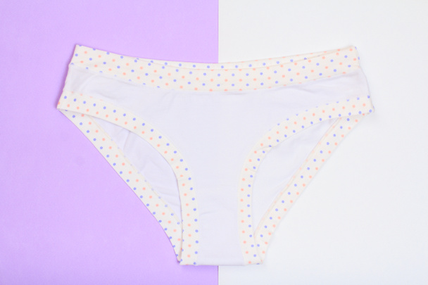 Prachtige slipje op lila en wit achtergrond. Vrouwen ondergoed set. Romantische lingerie. Bovenaanzicht. - Foto, afbeelding