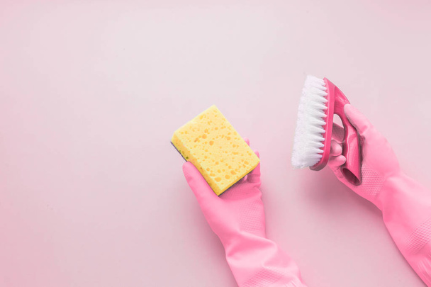 Flat lay Detergents and cleaning accessories and womens hands in rubber gloves in pink color. Cleaning service concept. Flatlay, Top view. - Valokuva, kuva