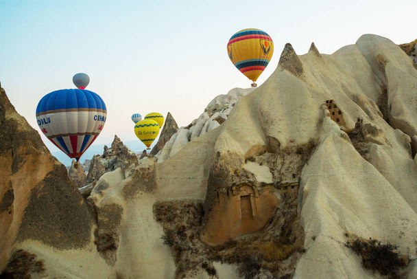 Many colorful hot air balloons flight above mountains - panorama of Cappadocia at sunrise. Wide landscape of Goreme valley in Cappadocia - billboard background for your travel concept in Turkey. - Foto, imagen