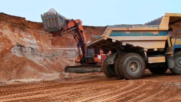 Graafmachine zand in Kipper vrachtwagen laden. Rups graafmachine graven bodem - Video
