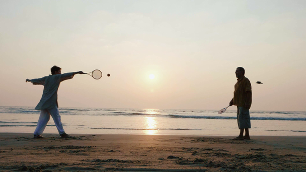Aktív vezető néhány tai chi-ballon labdáztak a tengerparton lassítva. - Felvétel, videó