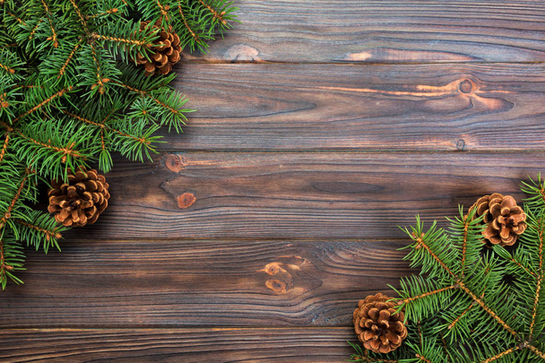 Fondo de madera gris navideño con marco de abeto y conos espacio de copia. vista superior espacio vacío para su diseño
. - Foto, Imagen