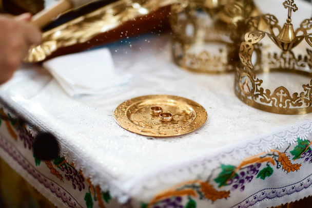 arany jegygyűrűk közel az oltár a templomban az esküvő pár a hagyományos vallási esküvő. - Fotó, kép