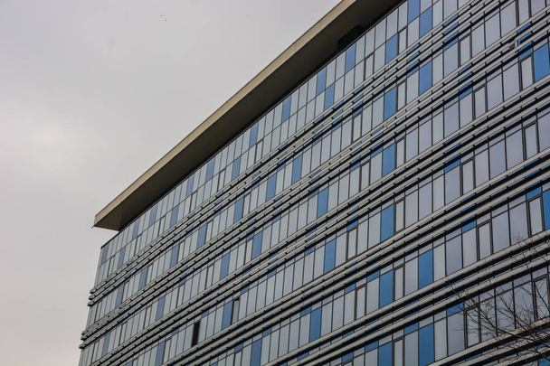 futuristisches Gebäude. eine moderne Struktur mit einer geschwungenen Glasfassade. abstraktes Architekturfragment. Blick in den Winkel des Eckgebäudes. - Foto, Bild