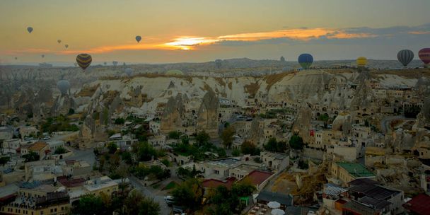 Landscape of Goreme at dawn. Hot air balloons over mountain landscape in Cappadocia, Goreme, Turkey. Aerial view from air balloon. - Фото, изображение