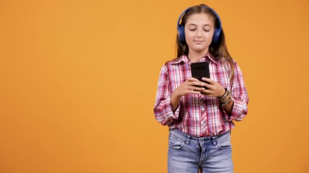 Mooie jonge meisje luisteren muziek terwijl het zoeken in smartphone - Video