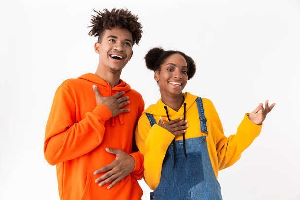 Image of happy african american couple in colorful clothes laughing at camera isolated over white background - Fotografie, Obrázek
