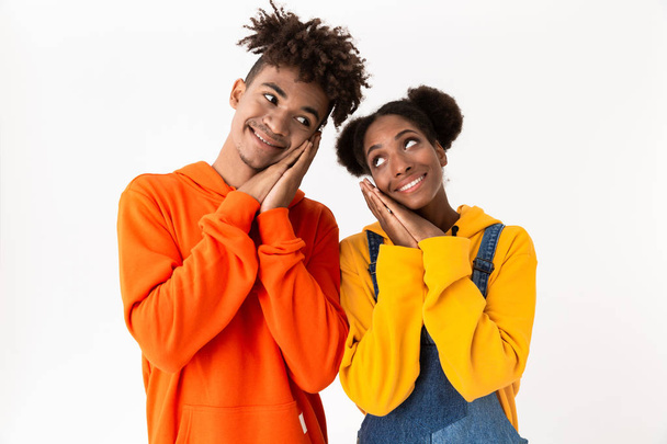 Image of affable african american couple in colorful clothes smiling at camera isolated over white background - Фото, зображення