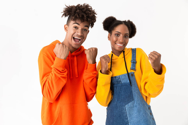 Image of african american man and woman 20s in colorful clothes clenching fists isolated over white background - Fotografie, Obrázek
