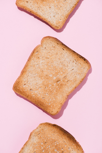 top view of row of delicious toasts on pink tabletop - Fotografie, Obrázek