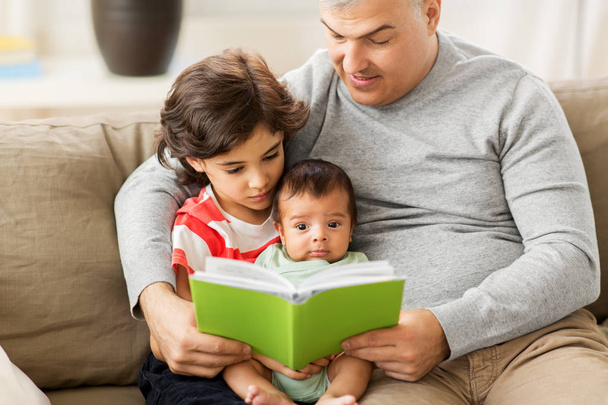 happy father with sons reading book at home - Foto, Imagem