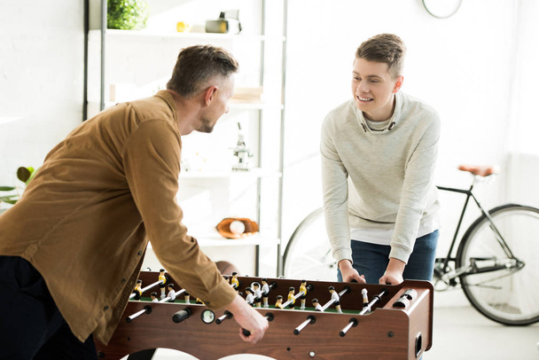 father and teen son playing table football together at home - Photo, Image