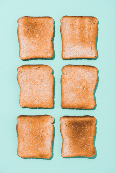 top view of assembled crispy toasts on blue surface - Fotó, kép