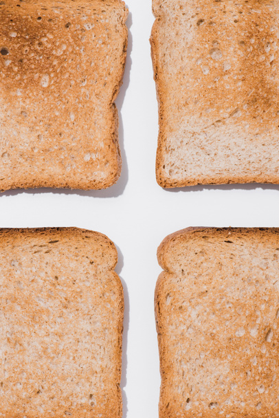 bovenaanzicht van geassembleerde toast op witte ondergrond - Foto, afbeelding