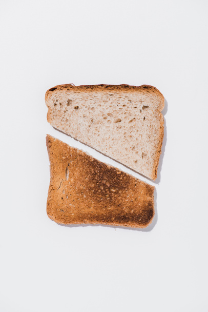 felülnézet szelet kenyér, a pörkölt fele fehér felületre - Fotó, kép