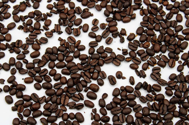 Roast coffee beans scattered on white background - Fotó, kép