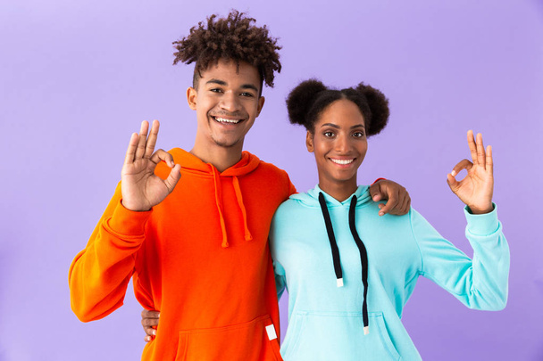 Photo of happy african american couple in colorful clothes showing ok sign isolated over violet background - Fotografie, Obrázek