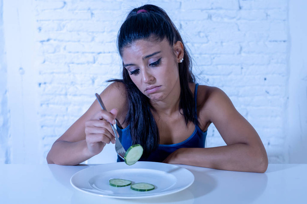 Portrait o f young attractive woman feeling sad and bored with diet not wanting to eat vegetables or healthy food in Dieting Eating Disorders and weight loss concept. - Zdjęcie, obraz