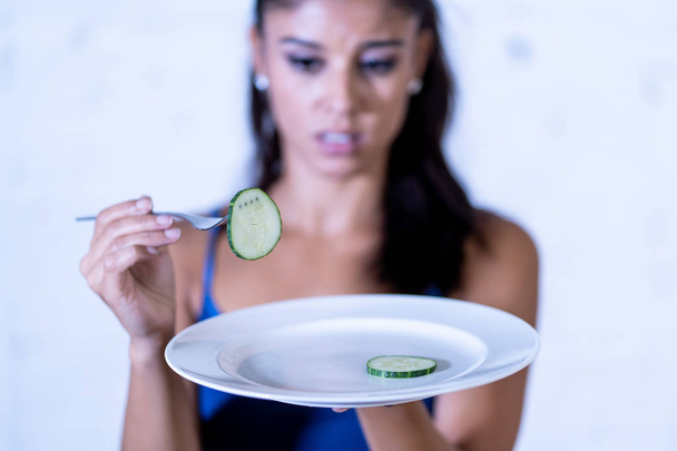 Portrait o f young attractive woman feeling sad and bored with diet not wanting to eat vegetables or healthy food in Dieting Eating Disorders and weight loss concept. - Foto, Imagem
