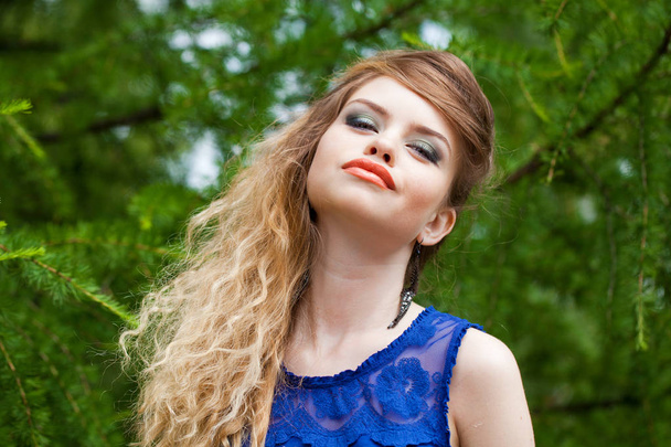 Portrait of beautiful young blonde woman, against summer green park. - Fotó, kép