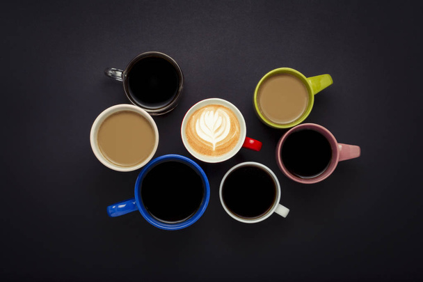 A lot of multicolored cups of coffee and coffee drinks on a black background. Concept of insomnia, coffee at night. Flat lay, top view. - Photo, Image