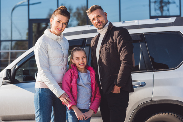  Preteen daughter standing with mom and dad near car  - Foto, afbeelding