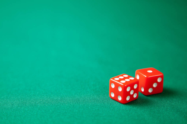 Dois dados vermelhos na mesa de jogos de poker verde no casino. Conceito de jogo online. Espaço de cópia para texto
 - Foto, Imagem