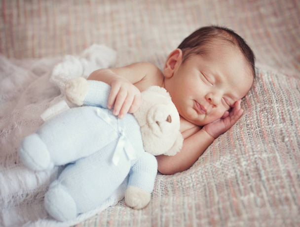 pequeño bebé está durmiendo dulcemente con un juguete en sus manos
. - Foto, imagen