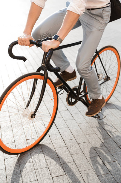 Photo of european man 30s wearing formal clothing riding on bicycle on city street - Foto, Imagen
