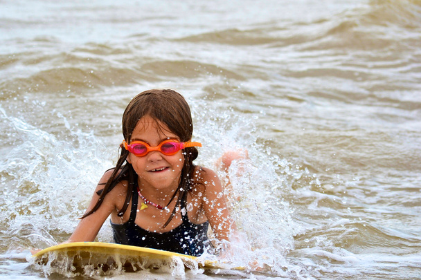 Nuori tyttö kehon surffailu rannalla
 - Valokuva, kuva
