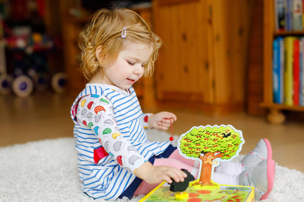 Rozkošný roztomilé malé batole dívka si hraje s activity hra. Šťastné dítě zdravé dítě baví s dřevěné hračky doma nebo školky. - Fotografie, Obrázek