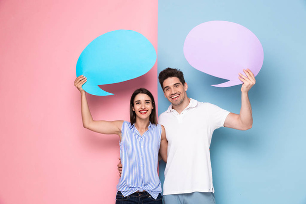 Image of optimistic couple holding copyspace commercial bubbles for text isolated over colorful background - Foto, immagini