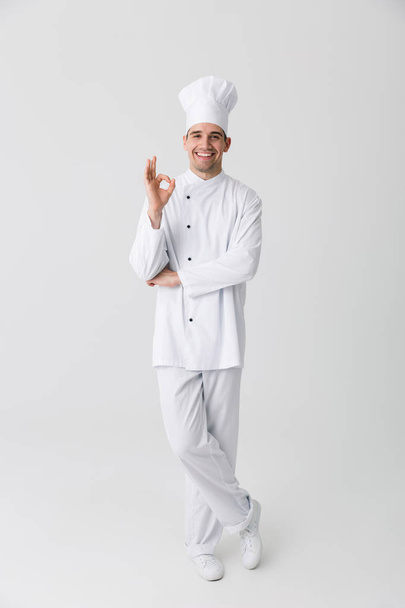 Image of handsome young man chef indoors isolated over white wall background. - Valokuva, kuva