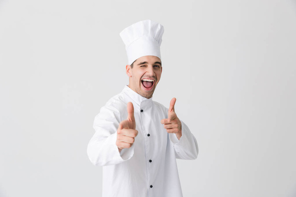 Image of handsome excited young man chef indoors isolated over white wall background pointing to you. - Valokuva, kuva