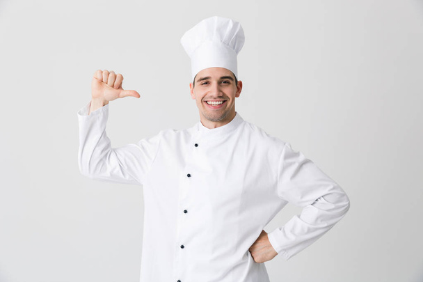 Image of handsome excited young man chef indoors isolated over white wall background pointing to himself. - Foto, afbeelding