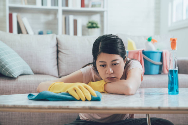 asian wife resting her head and arms on table in living room wants to take a nap. beautiful housewife doing housework in house. young lady feeling tired wiping table in the afternoon. - Zdjęcie, obraz