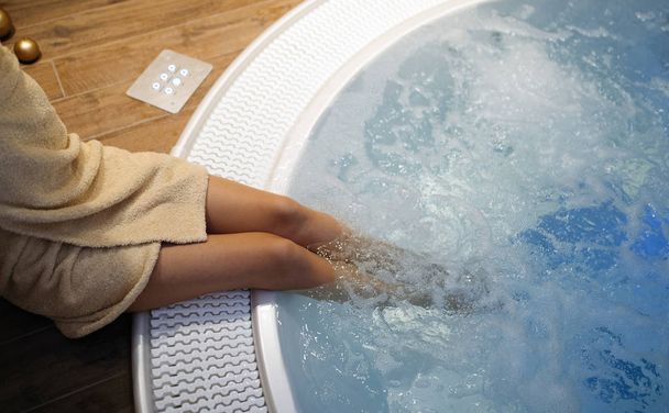 Woman enjoying jacuzzi relaxation at spa resort - Foto, afbeelding