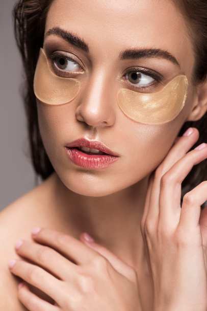 beautiful girl with golden collagen eye patches, isolated on grey - Foto, Imagem