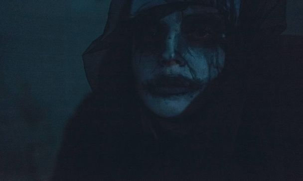 Portrait d'une femme dans l'obscurité vêtue d'un manteau à capuche noir et portant l'image d'une religieuse possédée par des démons. Cosplay
. - Photo, image