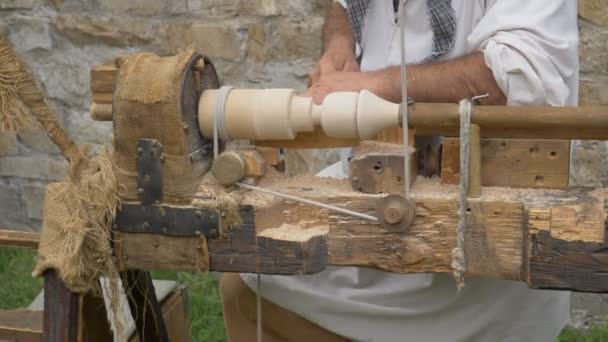 Старий чоловік, що працюють на стародавніх дерев'яних токарні під час реконструкція в Брено (Італія) на 12 серпня 2018. - Кадри, відео
