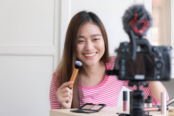 Asian woman are offering cosmetics through live broadcasts,Bloggers are smiling while reviewing products. - Photo, Image