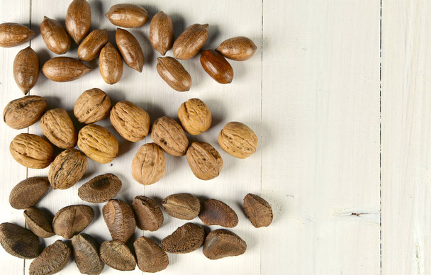 Tres variedades de nueces sobre una mesa de madera blanca
 - Foto, Imagen