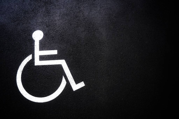 Osób niepełnosprawnych ikona lub symbol Handicap na miejsca parkingowe. Zarejestruj projekt na miejskich asfaltową drogą. Wózków inwalidzkich logo na puste pusty kopii przestrzeni. Pojęcie niepełnosprawności. - Zdjęcie, obraz