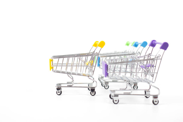 Colorful shopping carts on white background - Фото, изображение