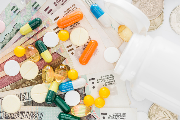 top view of various colorful pills and russian rubles on surface - Photo, Image